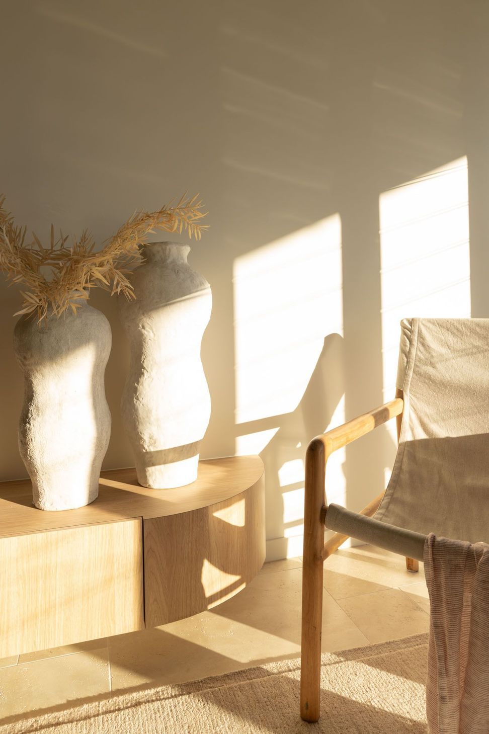 Warrego - Living Room. Sculptural vases and a canvas chair in the afternoon sun.