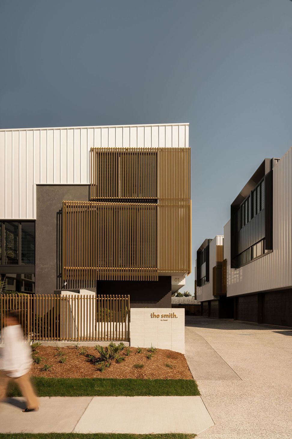 The Smith - Exterior. Townhouse facade with timber screens and a landscaped frontage.