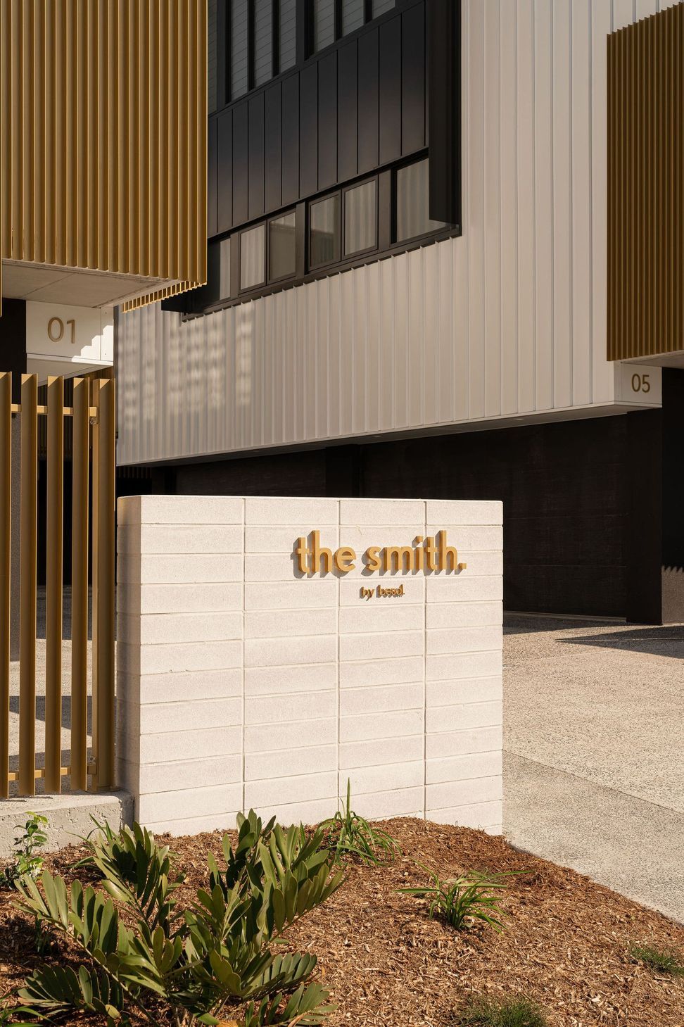 The Smith - Entry. Signage wall at the entry beneath timber screens.