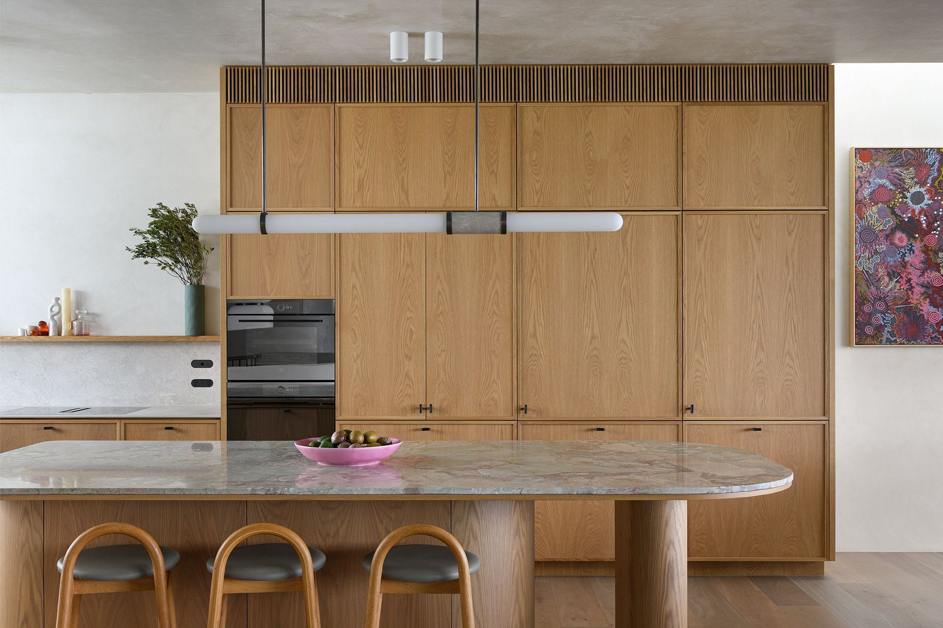 Villa Solare - Kitchen. Integrated ovens in warm timber joinery above the island.