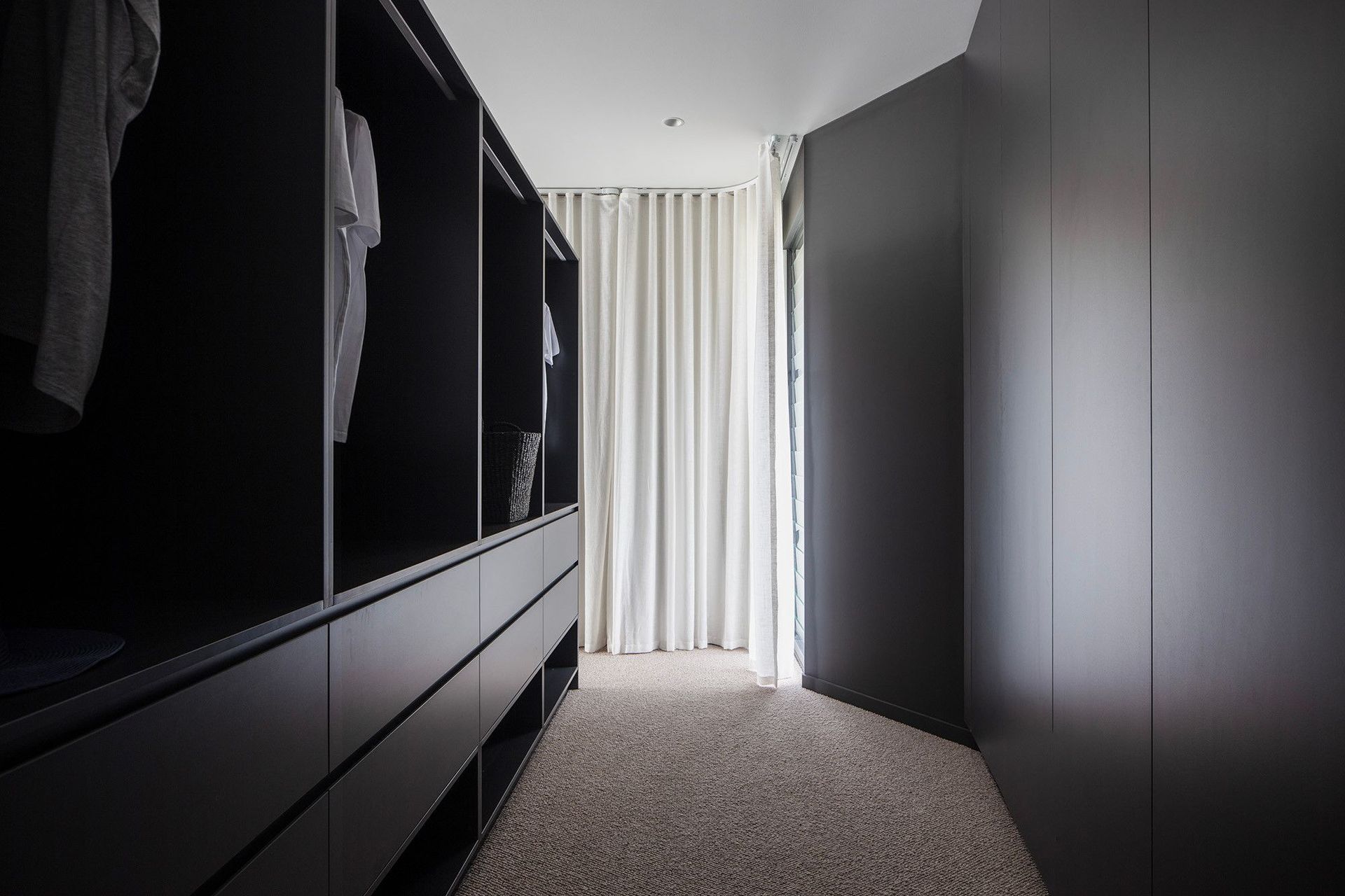 Bells Esplanade - Wardrobe. Walk in robe with dark joinery and sheer curtains.