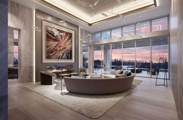 A sophisticated high-rise living room or lounge with floor-to-ceiling glazing overlooking a city skyline at sunset. The room features a large curved upholstered sofa, coffee table, area rug, sculptural lounge seating, a dramatic abstract artwork, and a compact bar or console beneath it. Pale stone-look wall and floor finishes, timber-toned surfaces, concealed linear lighting, exposed ceiling services, and extensive glass partitions create a refined contemporary interior with an airy, urban atmosphere.