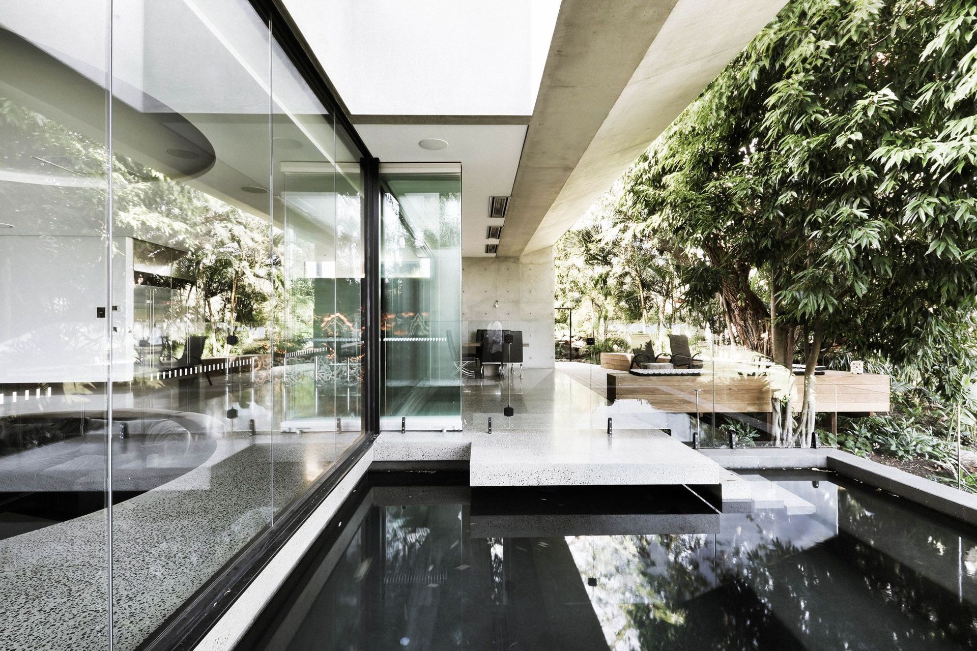McGovern Residence - Living Room. Glazed living space wrapping a reflection pond and courtyard tree.
