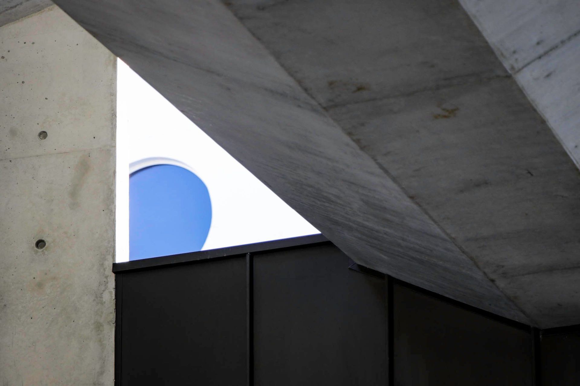 McGovern Residence - Exterior. Off-form concrete soffit and a circular skylight opening.