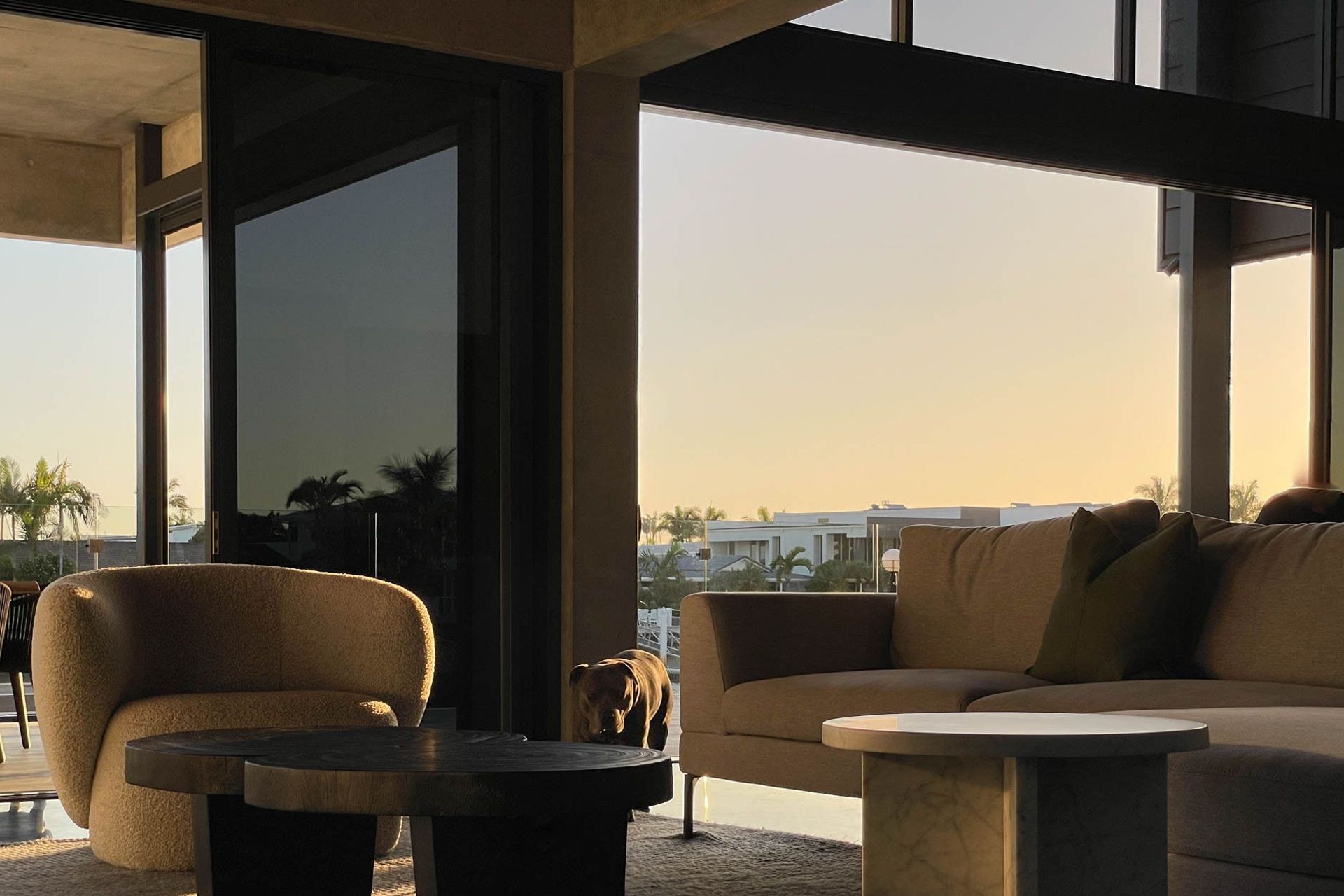 M Residence - Living Room. Lounge setting opening to the pool at dusk.
