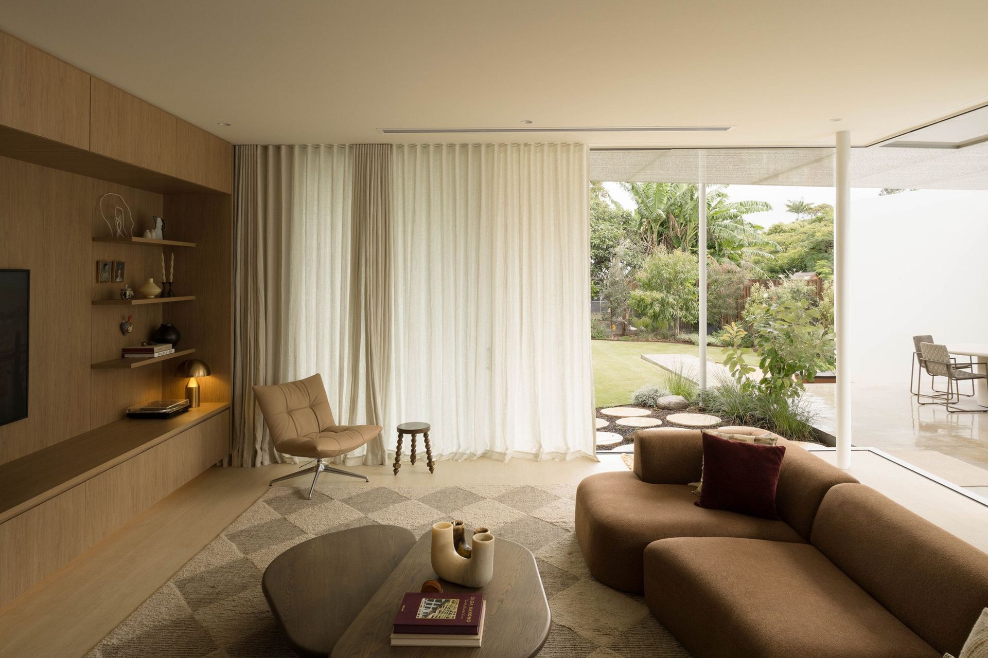 Henderson - Living Room. Lounge with a curved sofa opening to the garden.