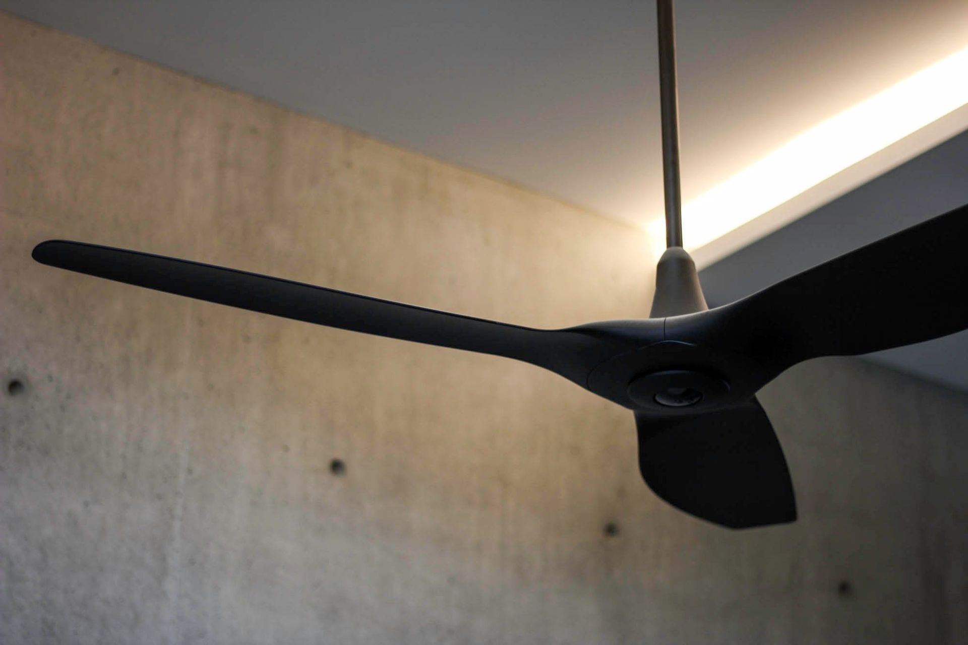 McGovern Residence - Living Room. Black ceiling fan against a concrete ceiling.