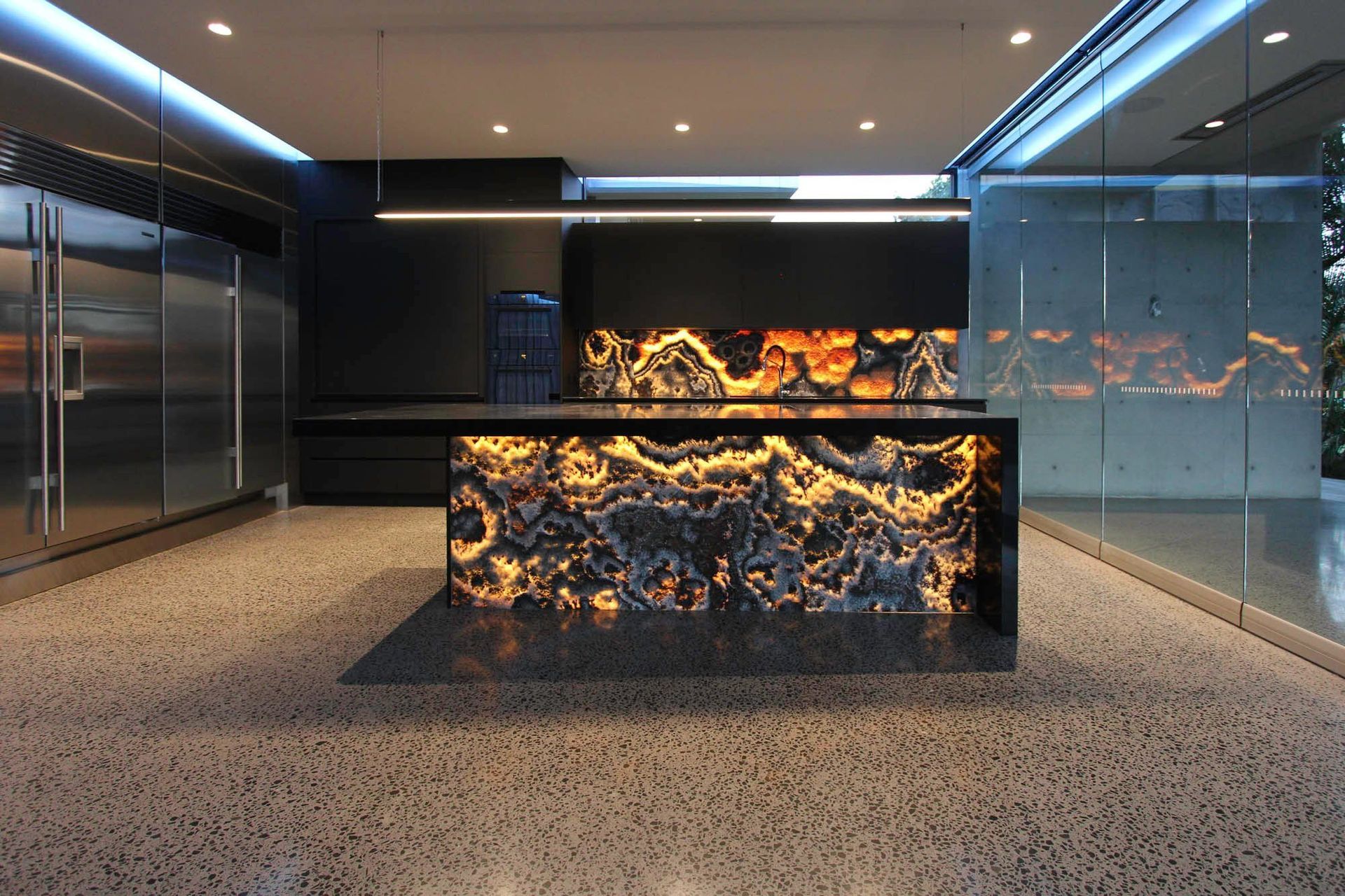 McGovern Residence - Kitchen. Backlit onyx island glowing beneath a skylight.