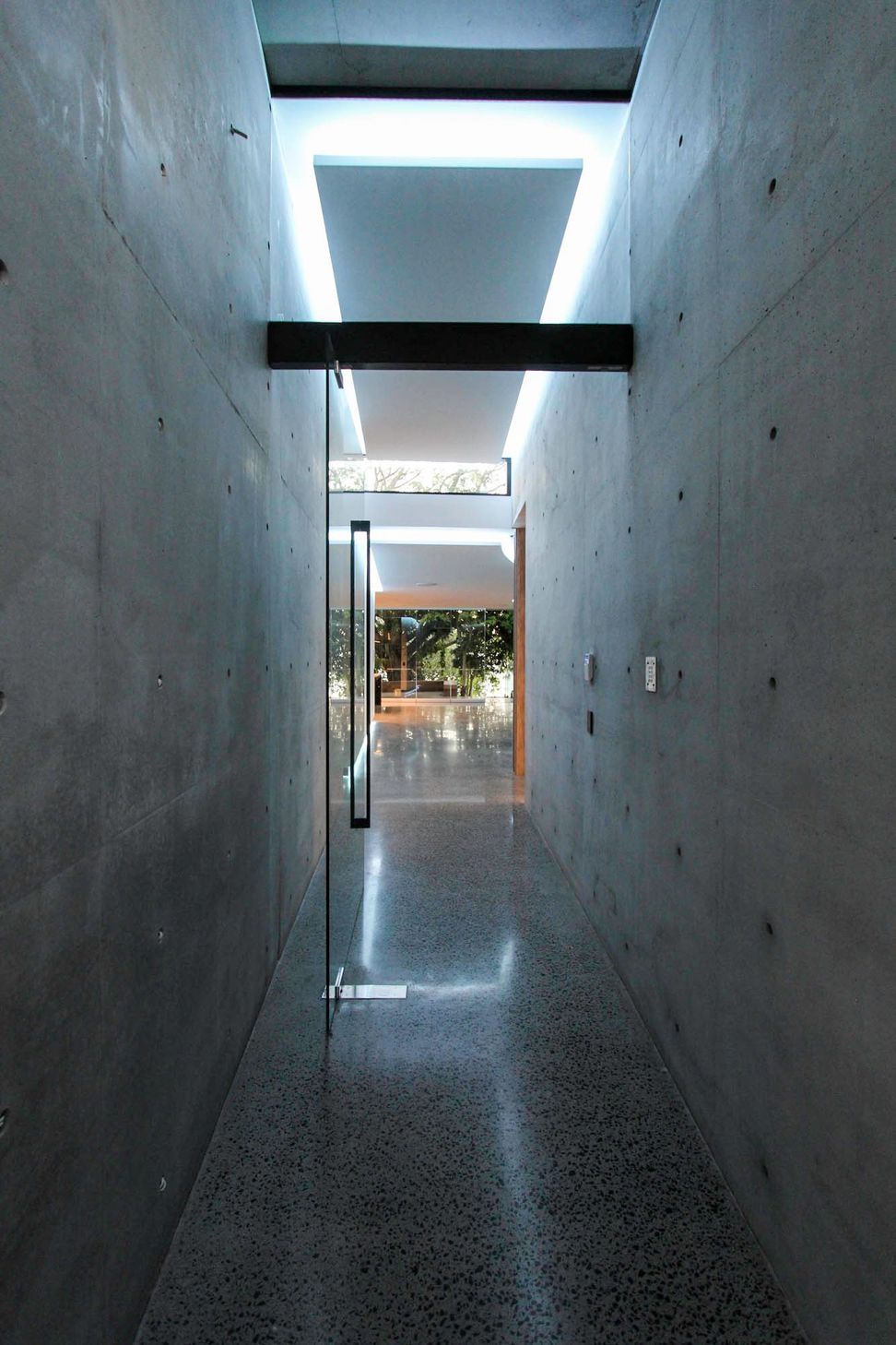 McGovern Residence - Hall. Concrete corridor leading to a glazed courtyard.