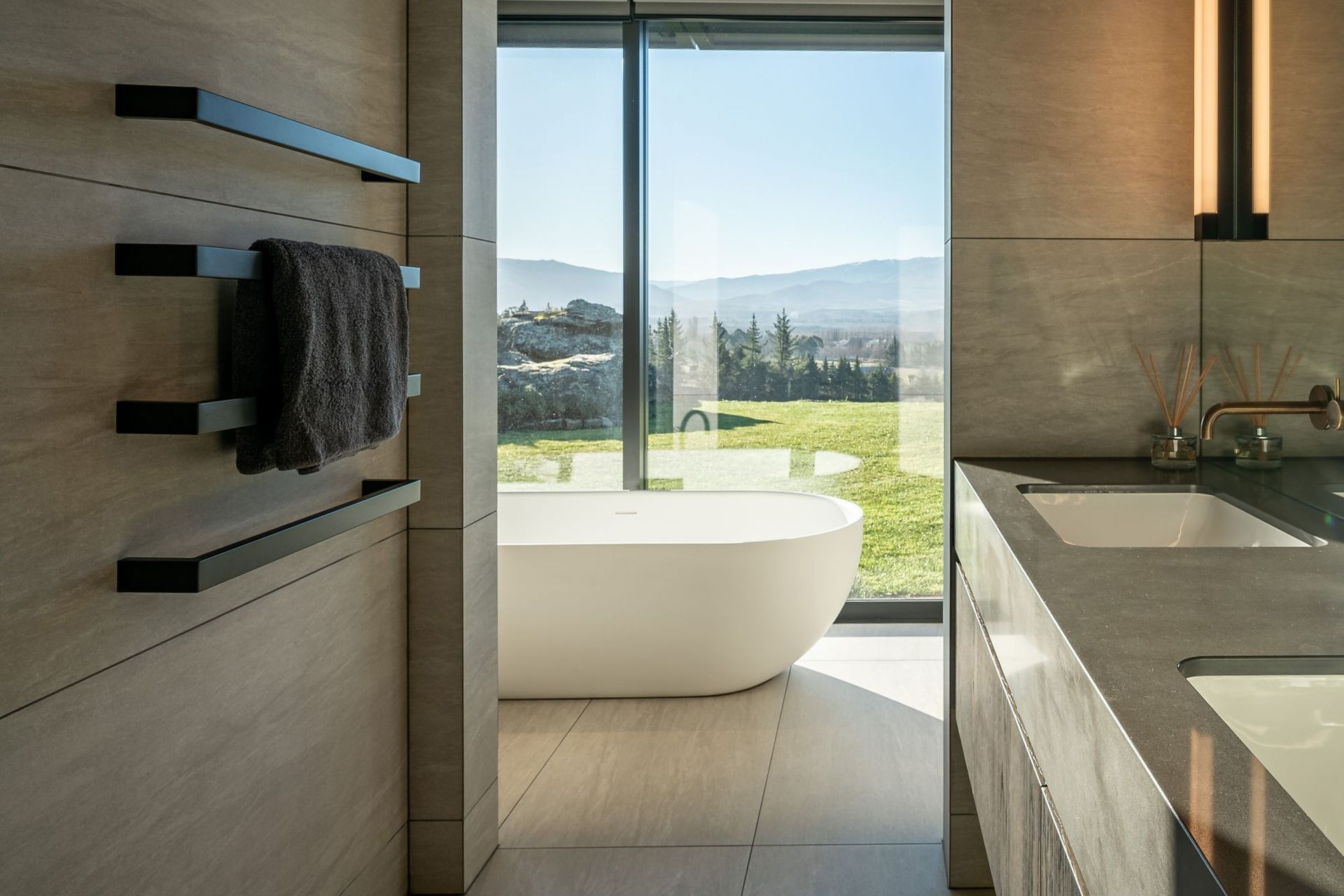 The master suite's freestanding bath enjoys an idyllic view to the lawn and views beyond.
