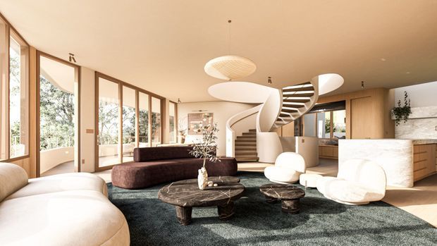 A bright, open-plan contemporary living room with expansive timber-framed glazing, curved cream seating, dark sculptural sofas, round stone coffee tables, a textured dark rug, and a dramatic white spiral staircase leading toward a timber-clad kitchen. The room has a warm neutral palette, organic rounded forms, and abundant natural light.