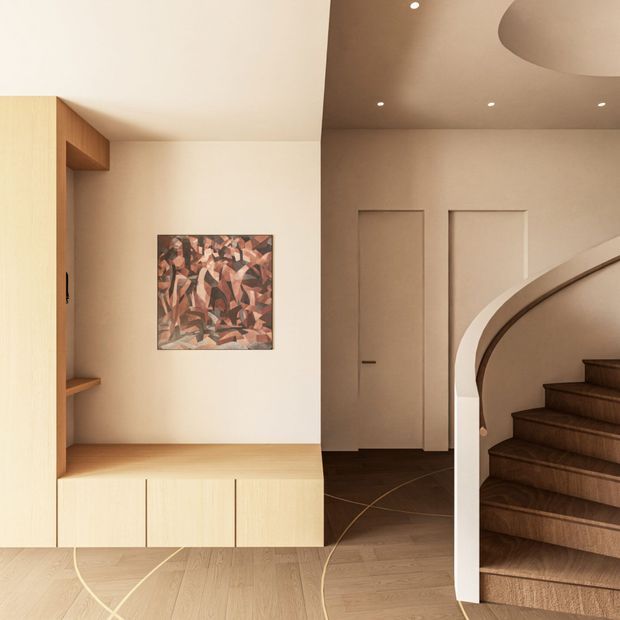 A warm, refined residential entry hall featuring a light timber built-in bench and display joinery, pale textured walls, dark timber flooring, and a sculptural curved staircase with dark wood treads and a white balustrade. Recessed ceiling lights and framed wall panelling contribute to the minimalist contemporary interior, with an abstract artwork providing a muted accent.