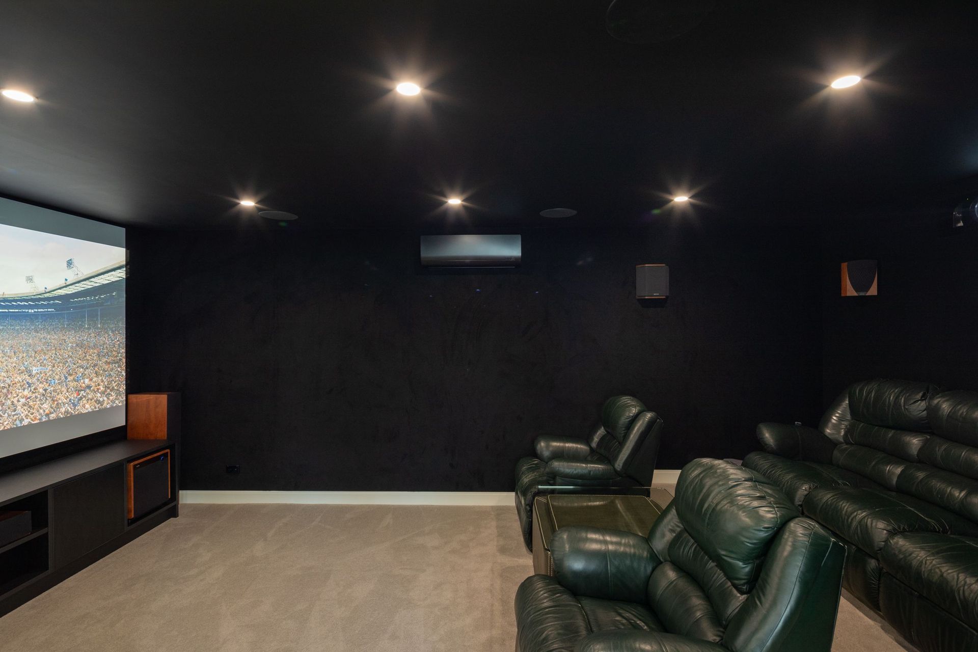 The dedicated home cinema provides an immersive entertainment experience with custom-built cinema seating, an oversized screen and carefully designed acoustics, creating a luxurious retreat within the home.