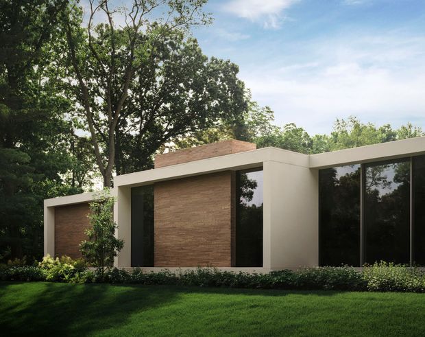 Modern single-storey house set within a mature landscaped garden, featuring a low horizontal flat-roof form, crisp light-coloured rendered walls, large dark floor-to-ceiling glazing, and warm timber-clad recessed wall sections. The restrained geometric facade contrasts with dense leafy vegetation and a manicured lawn.
