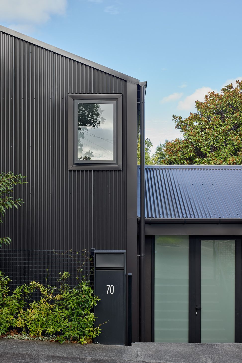 The street frontage of Home Sweet Home presents a contemporary interpretation of the classic gabled house. Clad in black corrugated metal with crisp aluminium joinery, the restrained material palette creates a confident yet understated presence within the neighbourhood.
