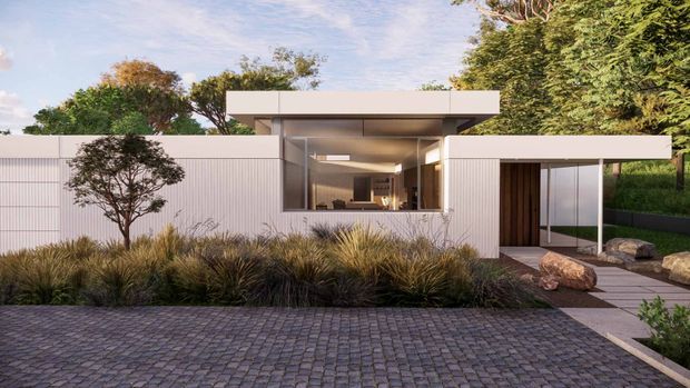 Contemporary single-storey residence viewed from the street, featuring crisp white horizontal and vertically ribbed cladding, a broad flat roof, expansive glazed living-area frontage, and a recessed timber entry door. Native grasses, sculptural rocks, and a small tree form a restrained front garden, while dark cobblestone paving leads toward the house.