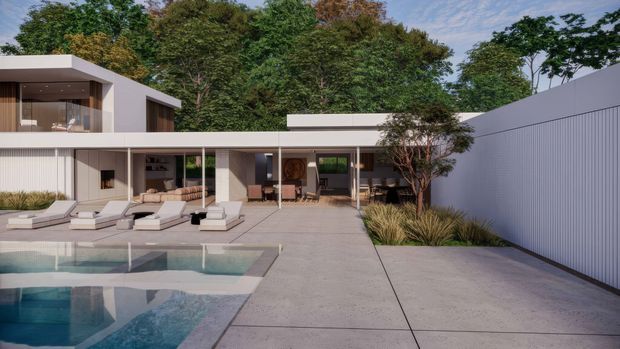 Contemporary flat-roofed residence viewed from a landscaped pool terrace. The home has crisp white rendered volumes, extensive floor-to-ceiling glazing, timber-toned window and door elements, a broad covered outdoor living zone, and a minimalist concrete-paved courtyard. A swimming pool, sun loungers, ornamental grasses, mature trees, and a tall light-coloured privacy fence complete the scene.