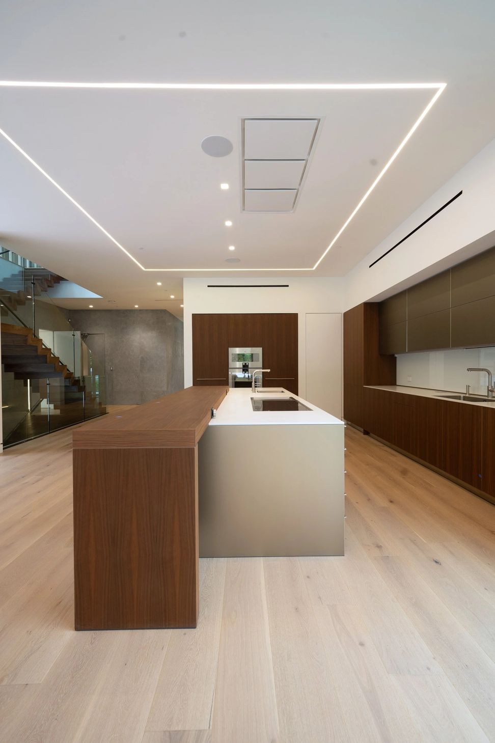 Strips of LED lighting frame the kitchen to create distinction between spaces within the open-plan interior.