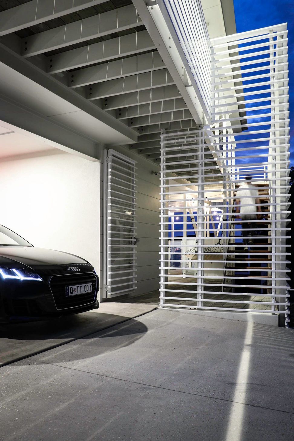 105 Residence - Garage. Car parked beside the slatted stair screen.