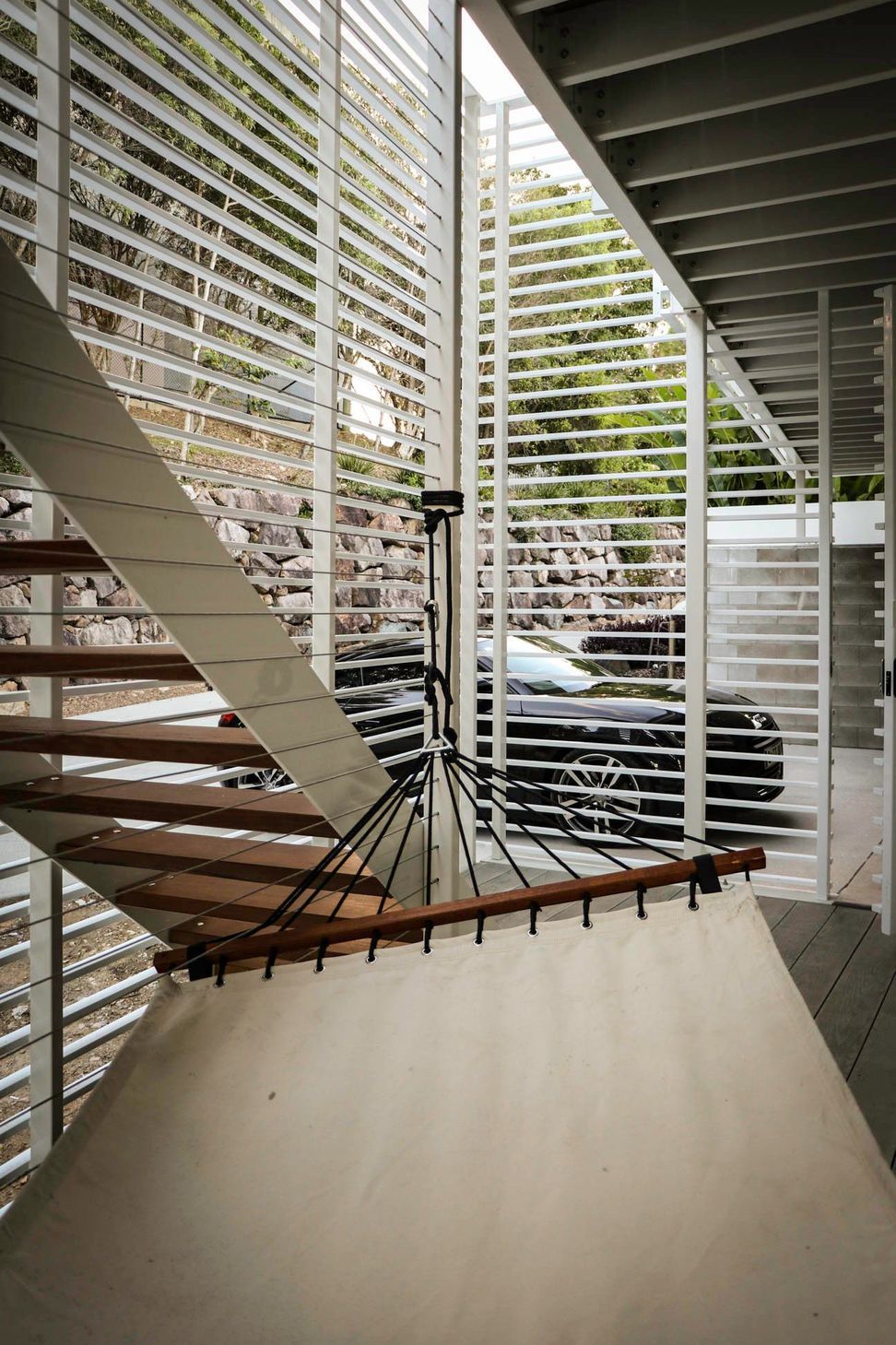 105 Residence - Staircase. Timber stair treads within the slatted stair tower.