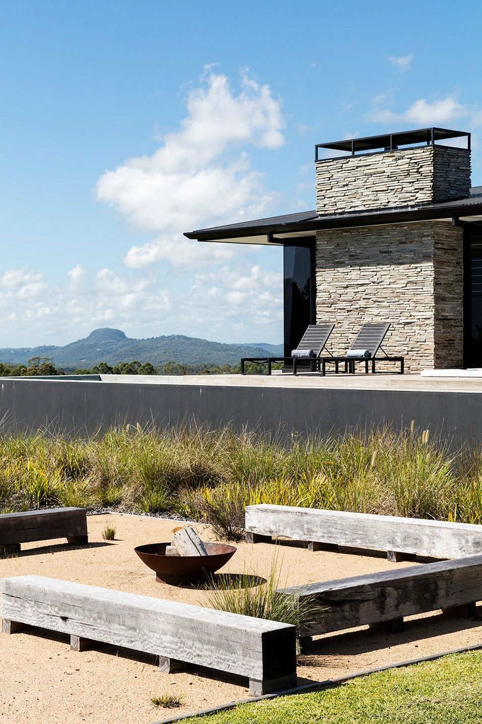 Clark Residence - Exterior. Stacked stone wall and terrace looking to the mountains.