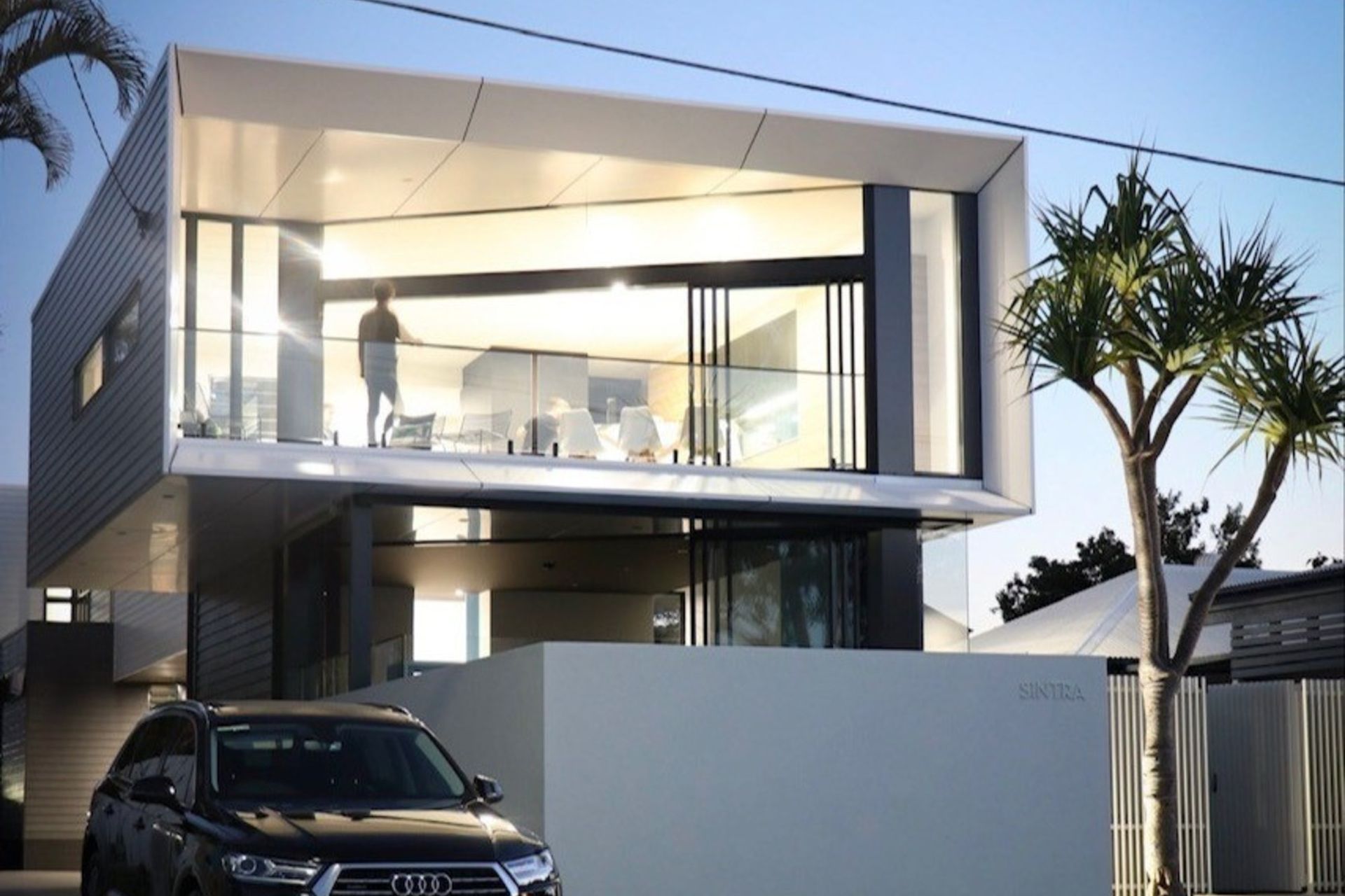 Kruger Residence - Exterior. Cantilevered upper level with full height glazing above the street.