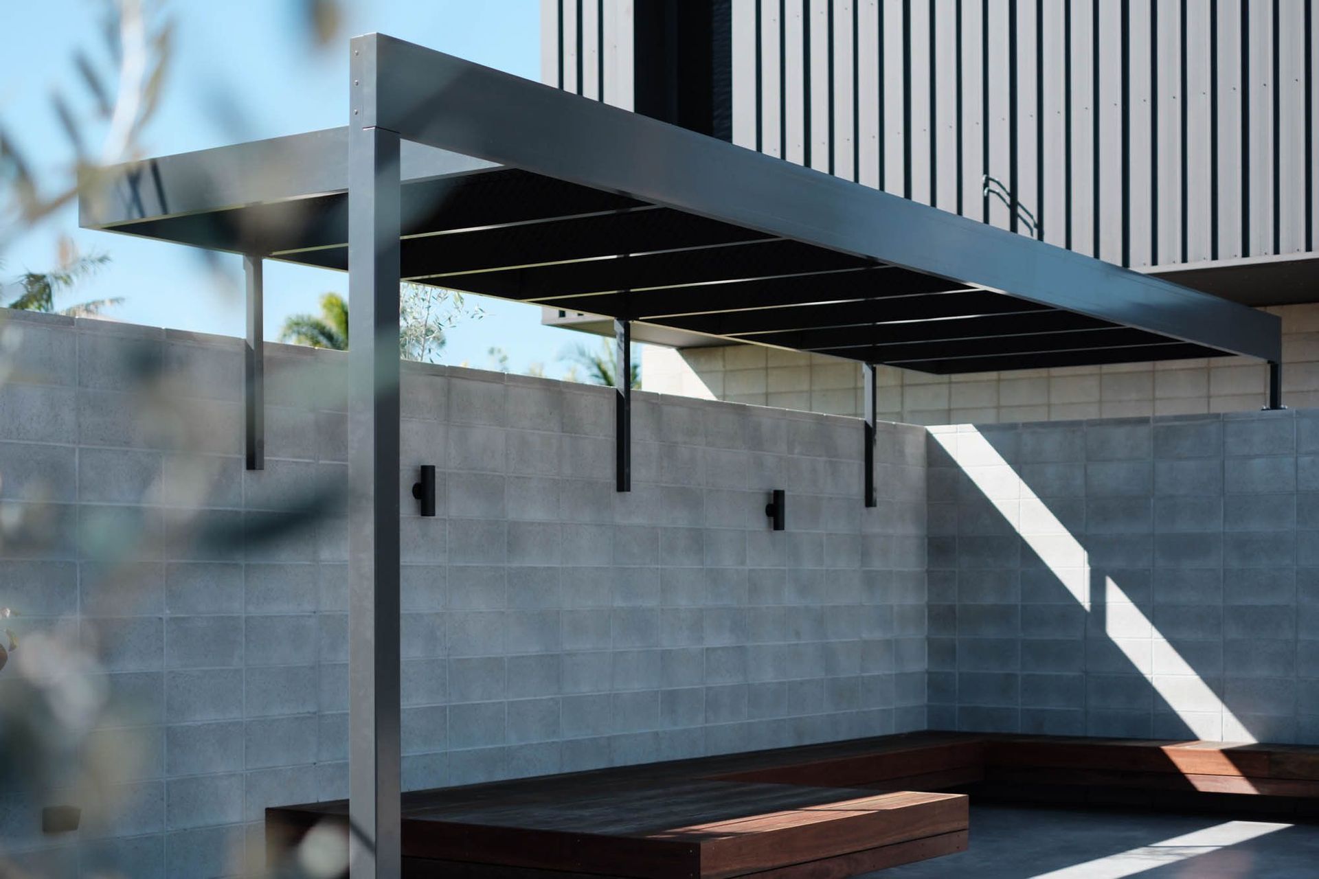 Seabrook and Borg Residence - Patio. Steel pergola casting shadows over the block walled terrace.