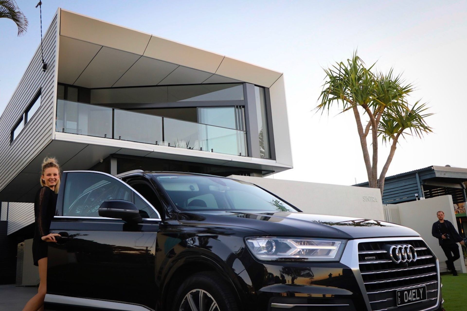 Kruger Residence - Exterior. Street frontage with the cantilevered glazed upper level and palms.