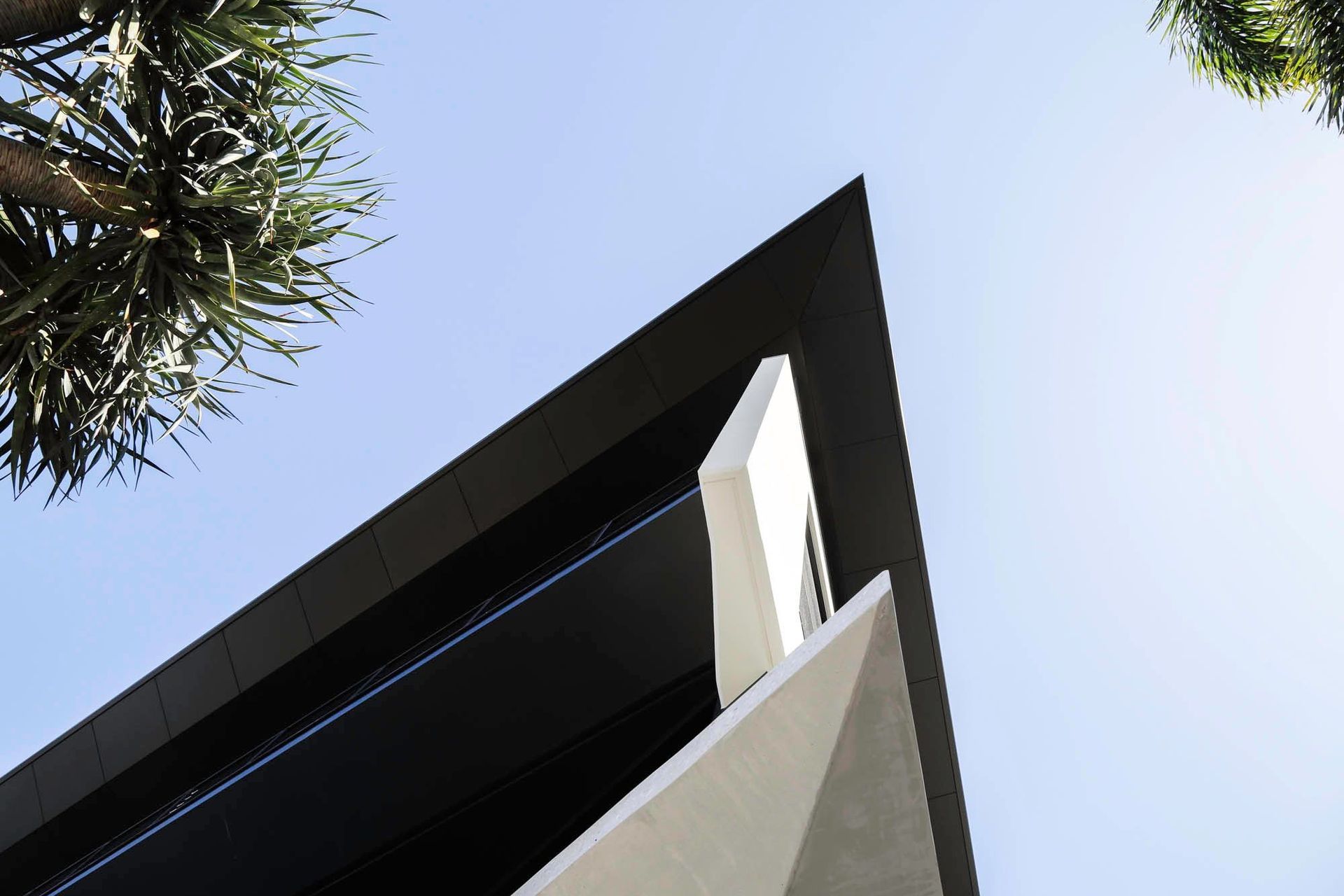 Robbie Residence - Exterior. Angled white roof edge cutting into the sky.