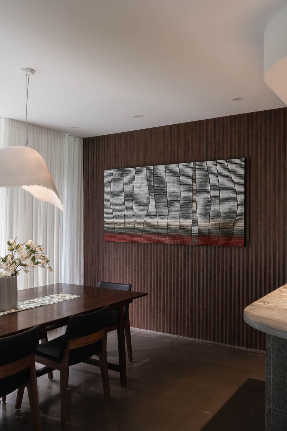 Eleutheria - Dining Room. Dining space with a timber clad feature wall and artwork.