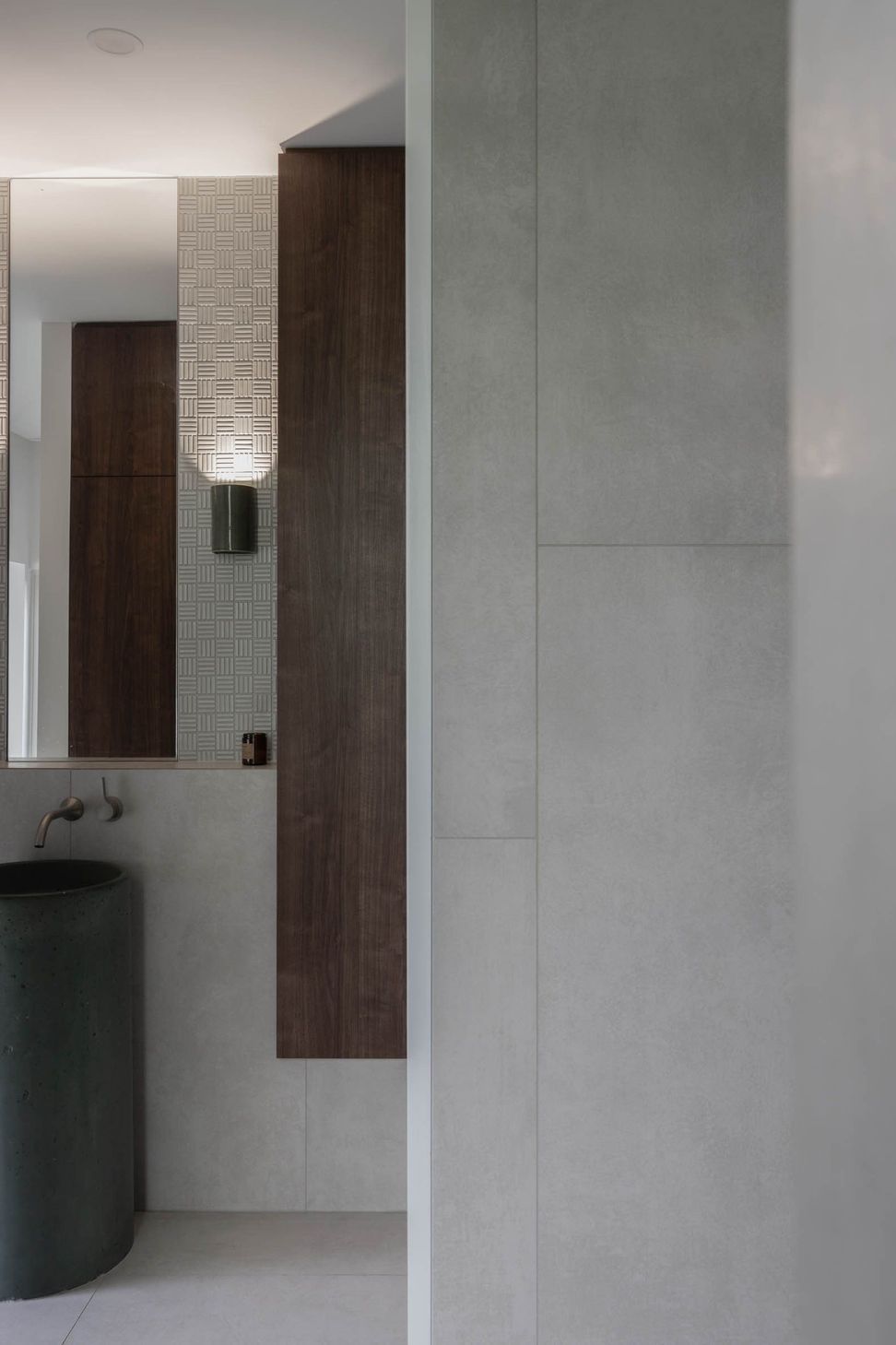 Eleutheria - Powder Room. Dark pedestal basin set against timber and concrete walls.