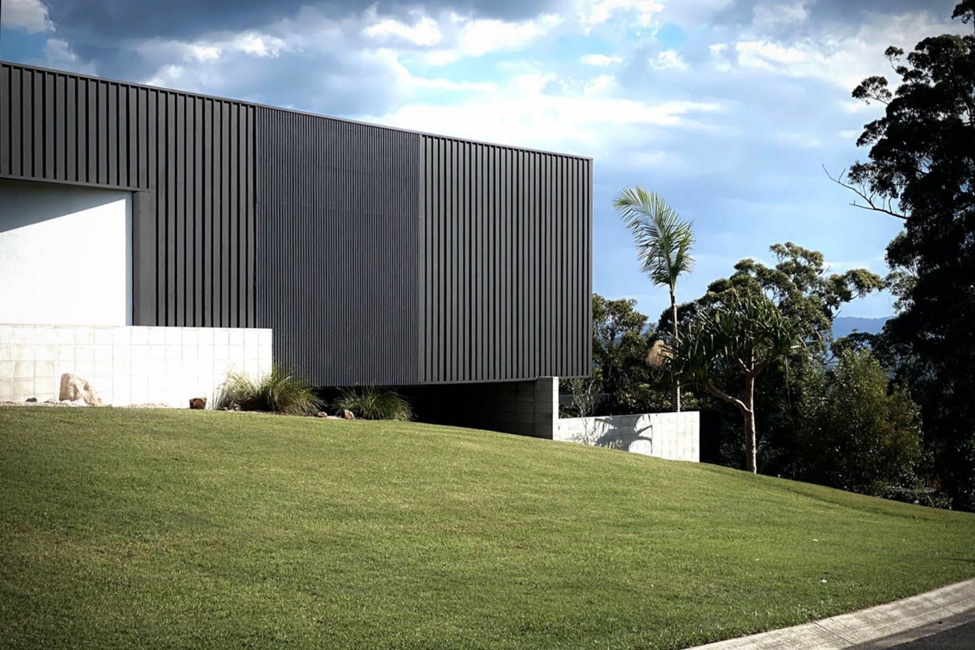 Seabrook and Borg Residence - Exterior. Dark clad volume floating above the lawn.
