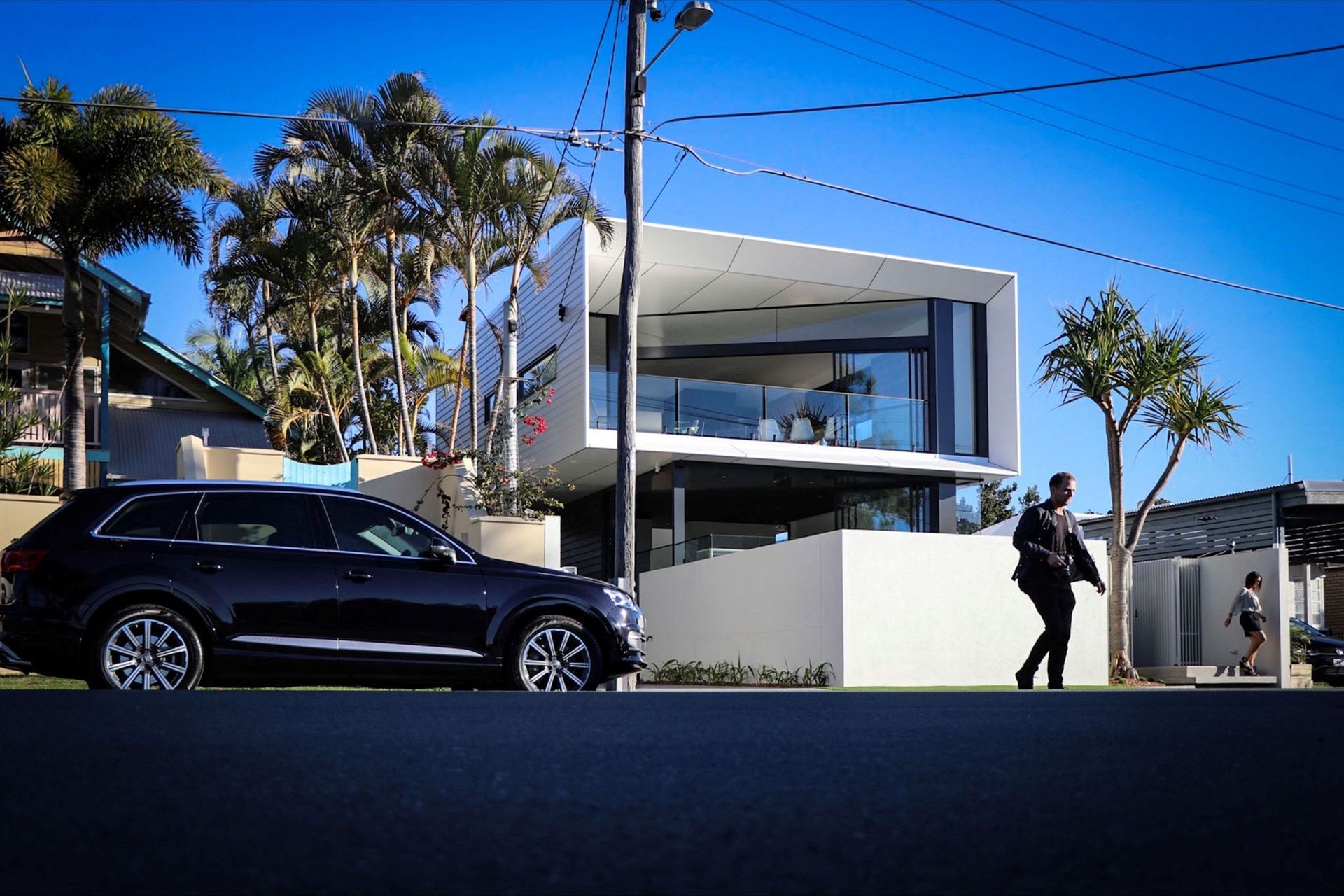 Kruger Residence - Exterior. The home from the street with palms and a blue sky.