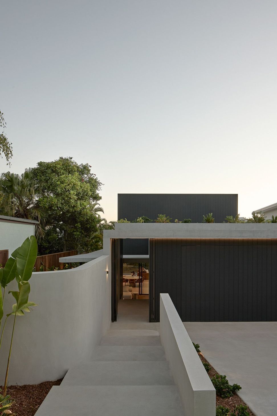 Wildflower Residence - Exterior. Dark clad upper level over a white rendered base.