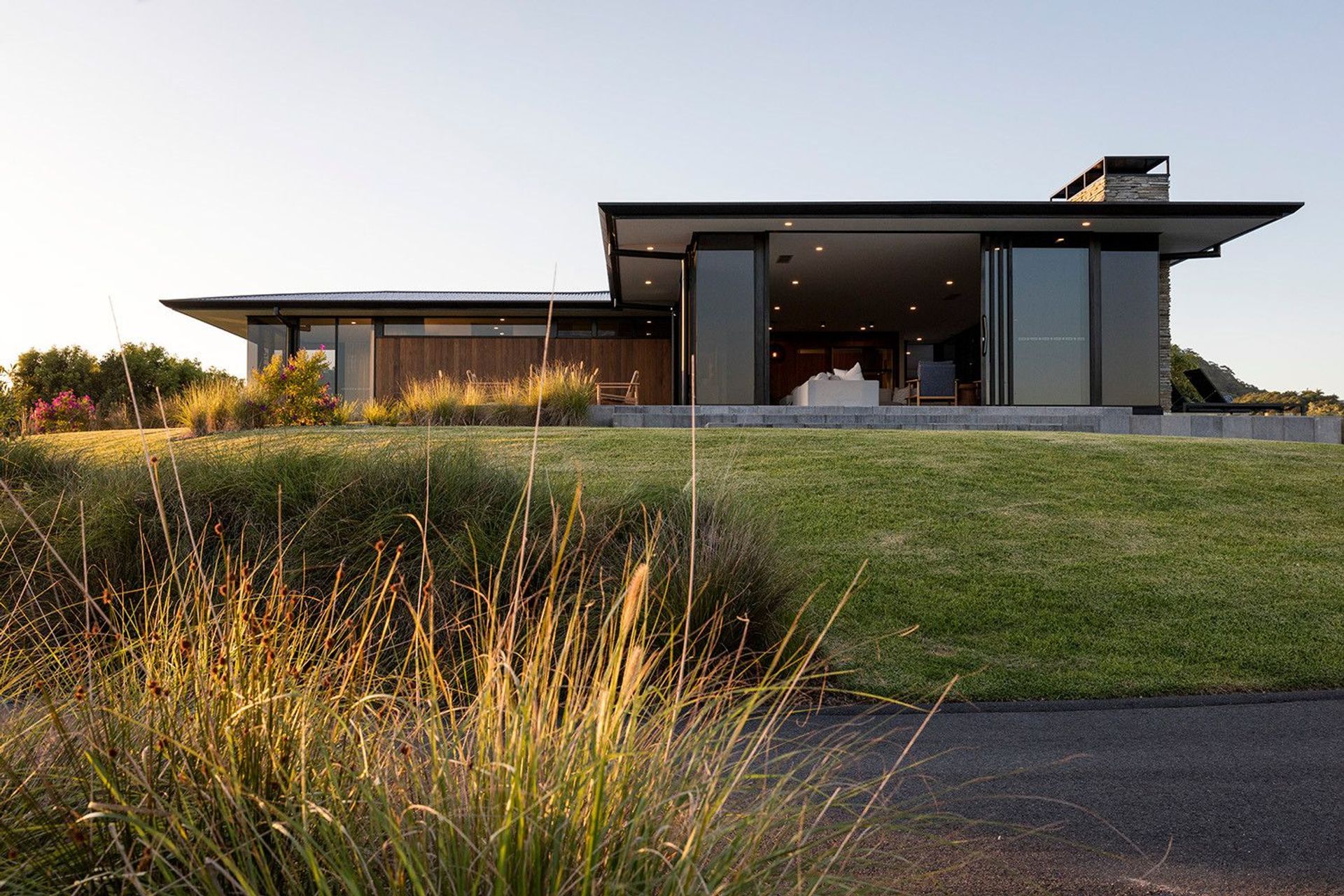 Clark Residence - Exterior. Long low facade set among native grasses.