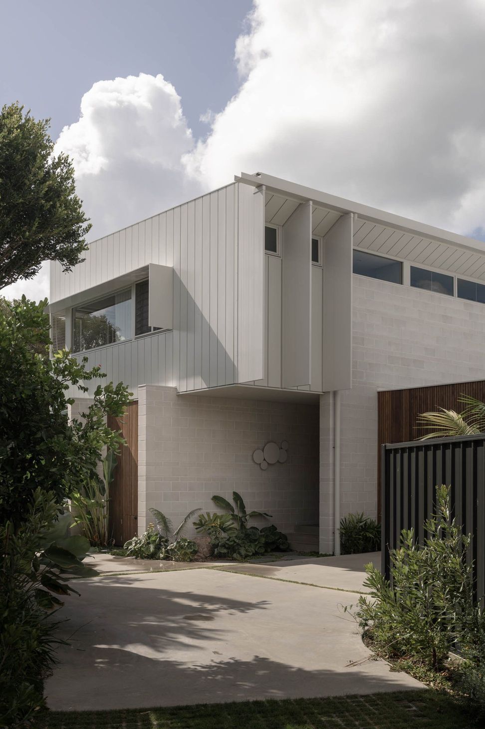Eleutheria - Exterior. Front elevation with clerestory windows and a timber clad entry.