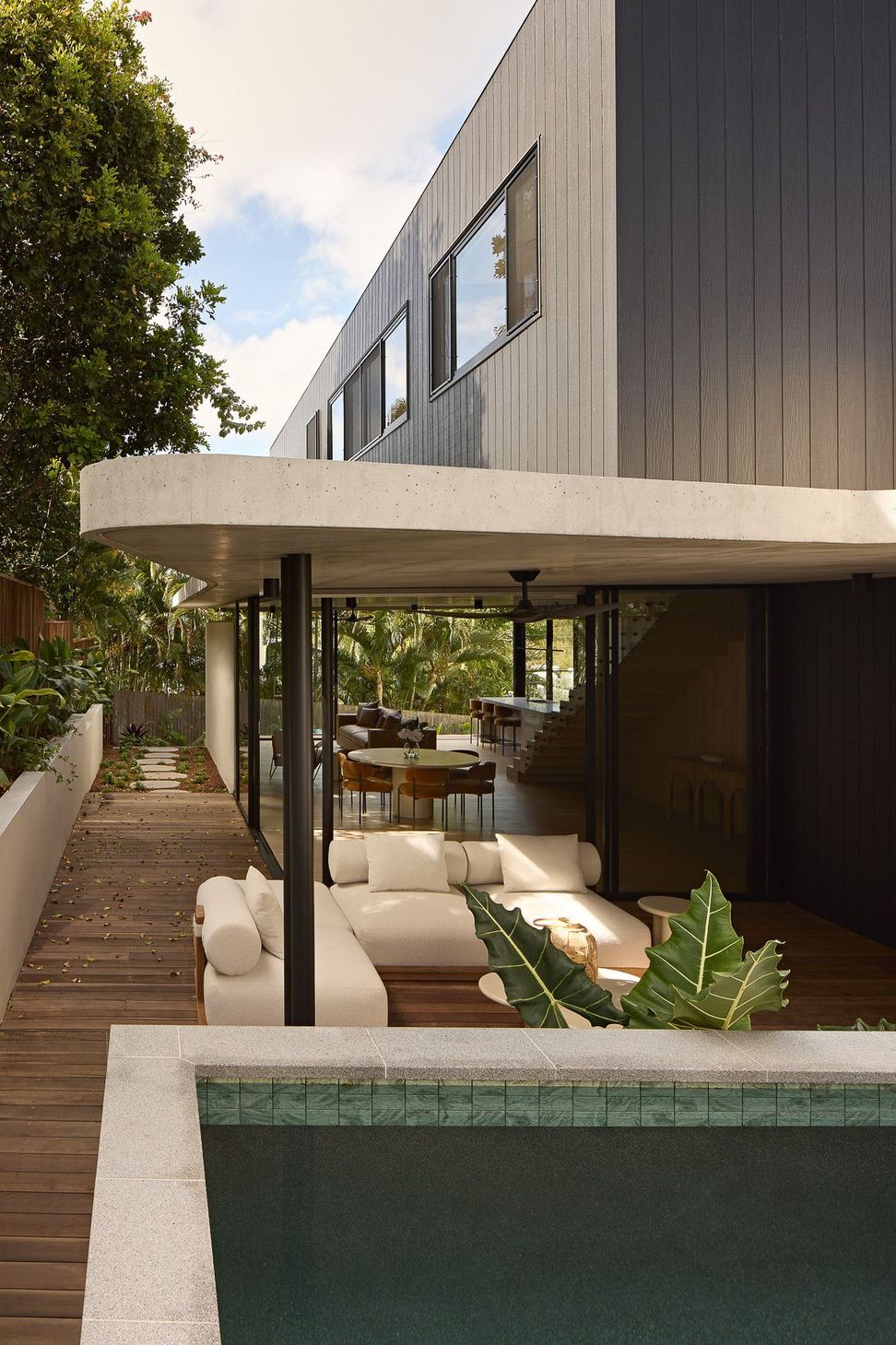 Wildflower Residence - Pool. Pool deck and outdoor lounge under the sculpted canopy.