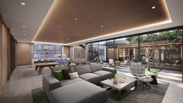Sophisticated open-plan living room with a large grey sectional sofa, sculptural lounge chairs, a low coffee table and a pool table positioned toward the rear. The space features a dramatic suspended timber-look ceiling with concealed perimeter lighting, dark vertical timber wall panelling, broad grey floor tiles, extensive floor-to-ceiling glazing, and views into a landscaped internal courtyard. Built-in shelving and a wine display wall add a refined hospitality-like character.