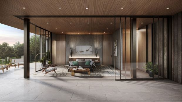 A refined contemporary living room opening onto a covered outdoor terrace. The space features extensive floor-to-ceiling glazing with dark slim frames, warm vertical timber wall and ceiling finishes, integrated shelving and fireplace-like cabinetry, a large neutral rug, a low timber coffee table, and modern lounge seating. A landscaped outdoor area is visible beyond the glazing.