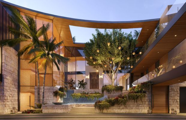 A dramatic contemporary architectural courtyard or entry forecourt viewed from outside, framed by sweeping curved timber-lined roof forms and cantilevered upper-level volumes. Natural stone walls, extensive glazing, warm concealed lighting, tropical palms, a central citrus-like tree, layered planters, and a shallow cascading water feature create a resort-like arrival space.