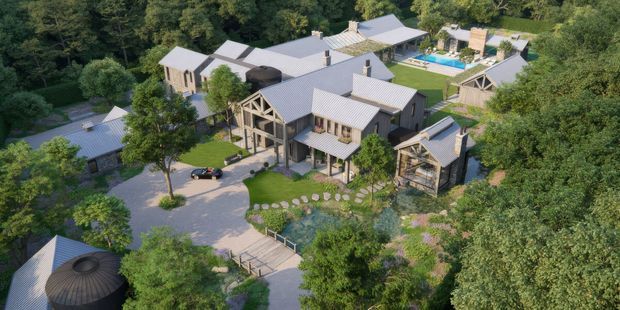 Aerial view of a large multi-building residential compound set within dense woodland and landscaped gardens. The buildings feature grey pitched metal roofs, light neutral wall finishes, timber-framed gable details, covered outdoor areas, and interconnected paths. A swimming pool and several courtyards or garden spaces are visible across the site.