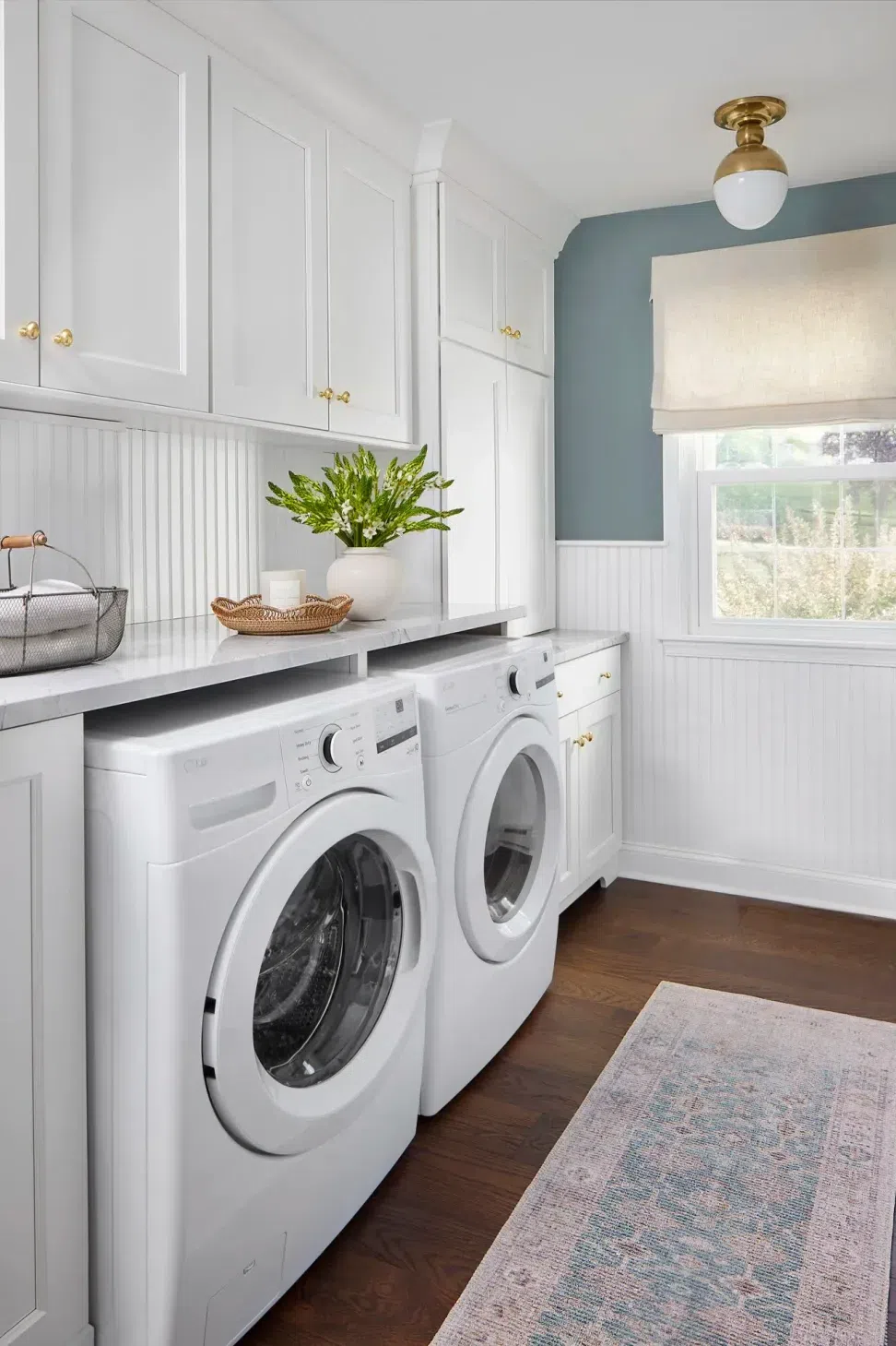 blue-wall-white-wainscoting-laundry-room-white-cabinets-marble-counter-top-sharp-and-grey-interiors-philadelphia-pa.webp