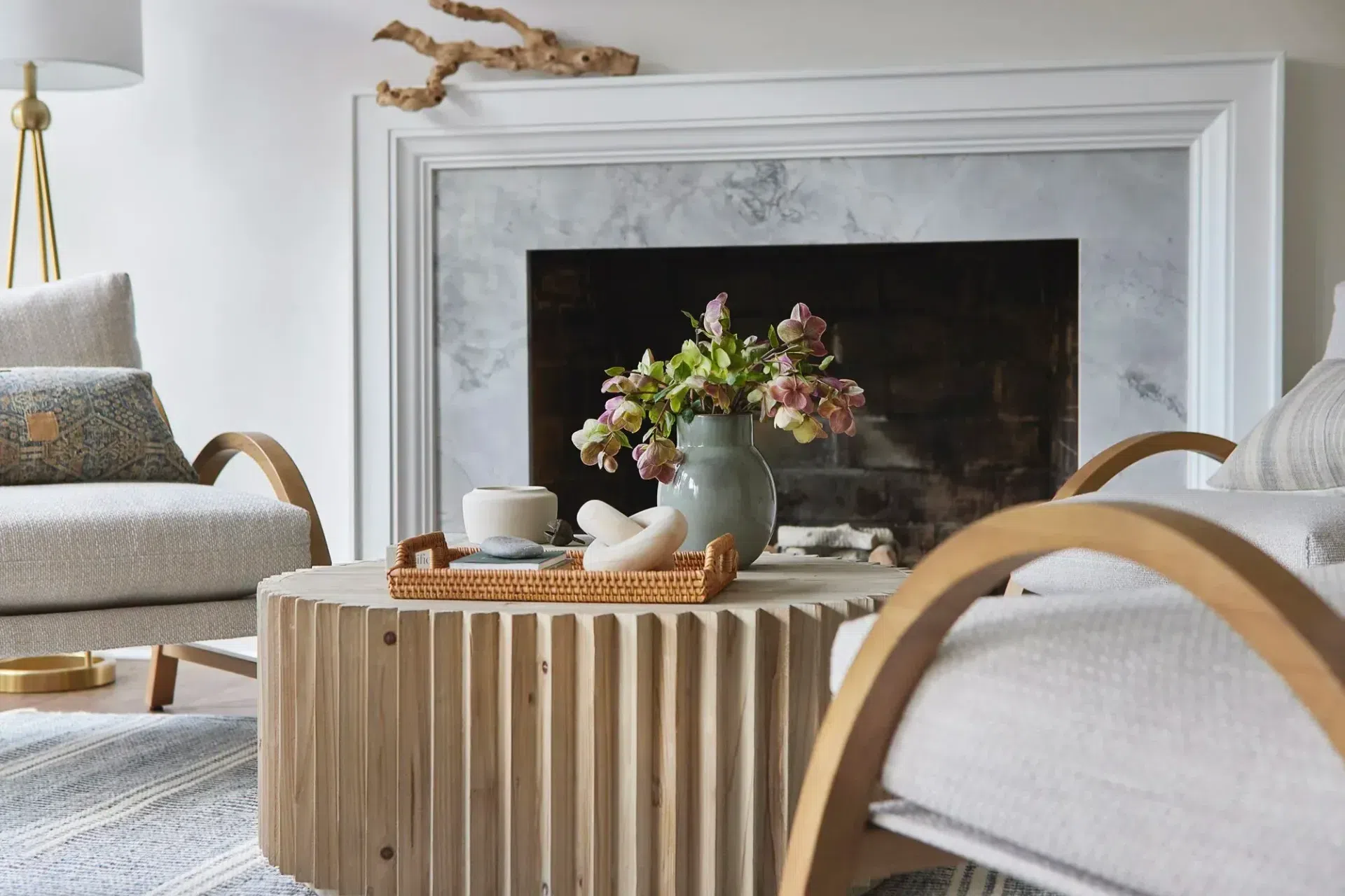 classic-modern-sitting-room-dark-hardwood-floor-stripe-rug-wood-coffee-table-marble-fireplace-sharp-and-grey-interiors-philadelphia-pa.webp