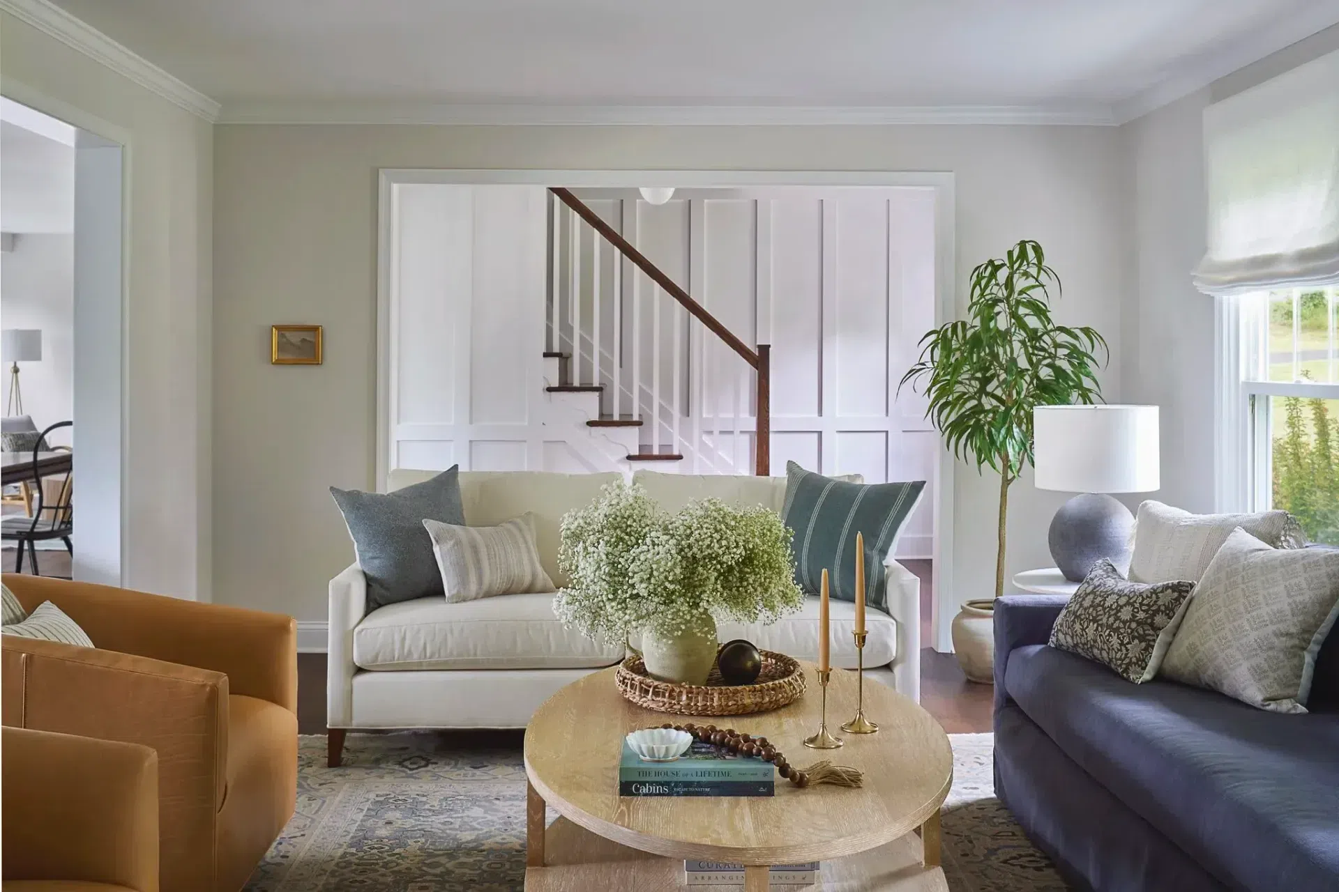 living-room-interior-design-modern-farmhouse-furnishings-leather-chairs-cream-decorative-pillows-sofa-white-board-batten-wall-sharp-and-grey-interiors-philadelphia-pa.webp