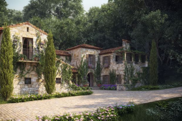 A picturesque multi-wing stone residence set among mature trees and landscaped gardens. The building has warm pale masonry walls, red terracotta tiled roofs, arched openings, dark timber shutters and doors, balconies with metal railings, and a broad paved forecourt bordered by flowering planting. The composition strongly evokes a Mediterranean or traditional European villa.