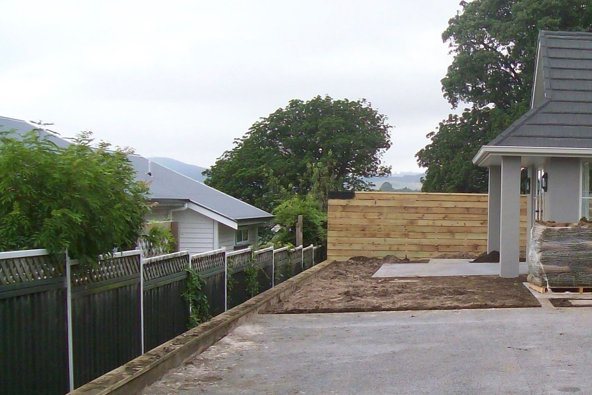 BEFORE — An exposed space — dominated by concrete, an unattractive fence, and direct views into the neighbours’ home.