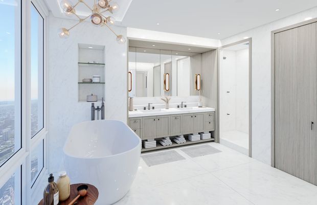 Bright, spacious contemporary bathroom with a freestanding white oval bathtub beside floor-to-ceiling glazing, a long double vanity with grey cabinetry and brass-toned hardware, large mirrors, open shelving, and a glass-enclosed shower. The room has predominantly white marble-look surfaces, pale flooring, recessed ceiling lights, and a decorative modern globe chandelier.