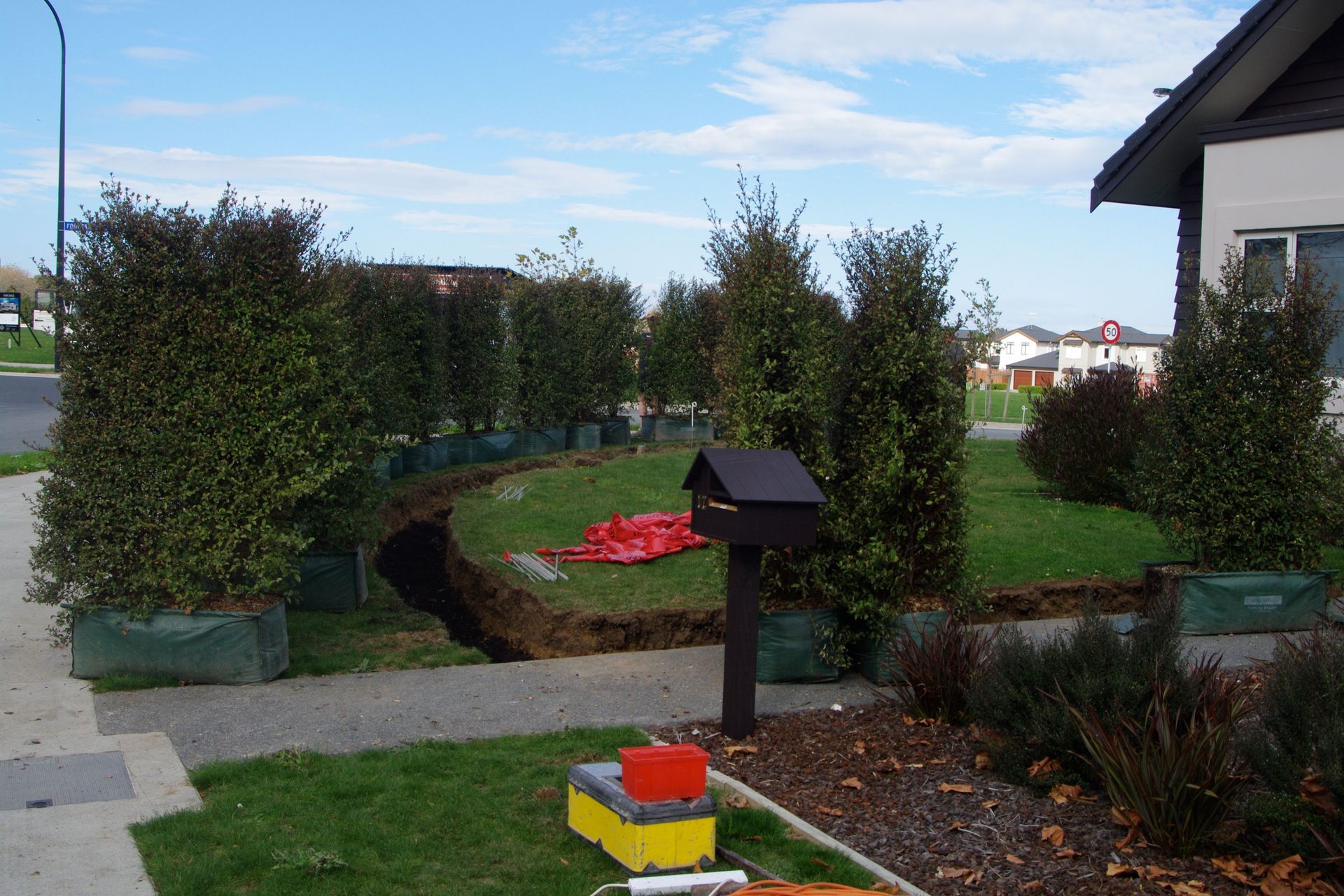 BEFORE – exposed corner site, trench dug ✔️, hedge delivered ✔️