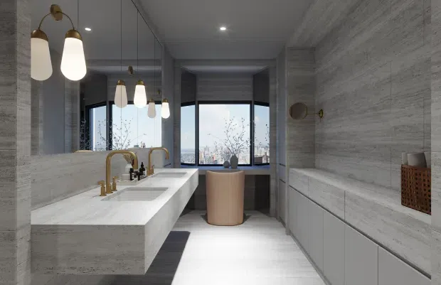 Contemporary bathroom with a long floating double vanity in pale stone, integrated basin, brushed brass tapware and pendant lighting. Full-height grey stone-look wall surfaces and matching built-in cabinetry create a refined, monochromatic interior. A freestanding bathtub sits in front of large dark-framed windows overlooking a city skyline, while a large mirror expands the room visually.