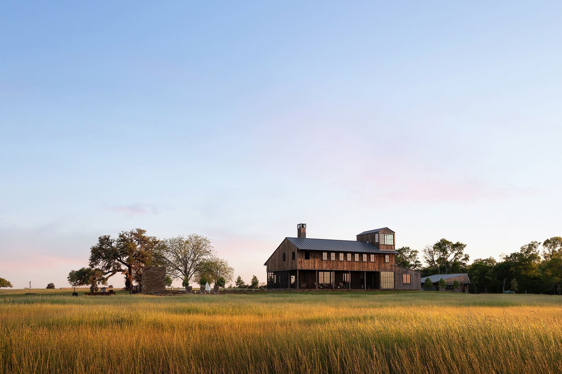 18HomeontheRangeCuppettKilpatrickArchitectureandInteriorDesigntwo-story-agrarian-metal-roof-field-sunset.jpg